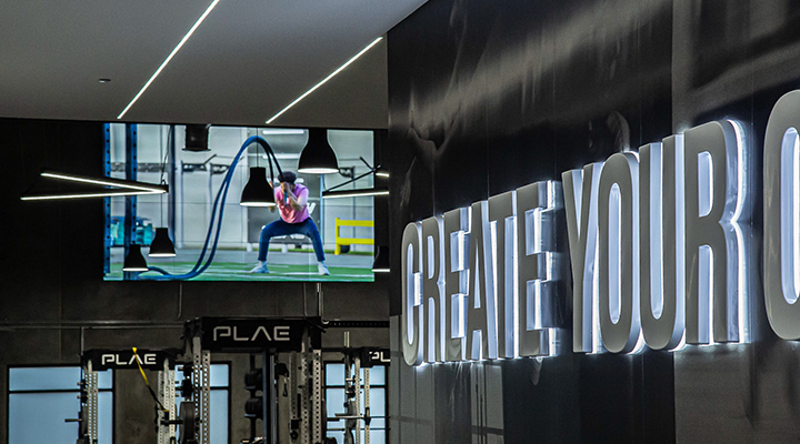 LG video walls display dynamic PLAE training content inside the FITNESS2020 PLAE Performance Zone, creating an interactive fitness environment that supports member engagement and workout performance.
