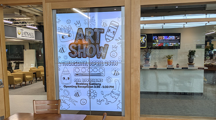 LG commercial digital signage display showing art show announcements at The Tatnall School entrance